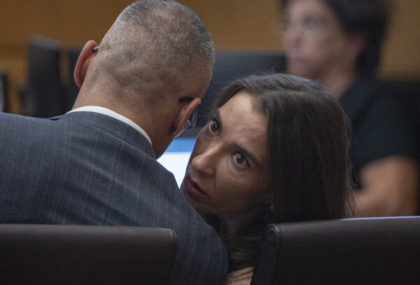 Laura Owens speaks to her attorney in court