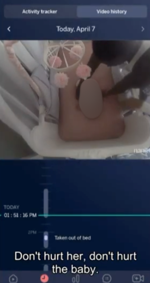 photo shows infant in a crib with arms coming to pick her up